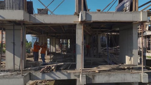 Vista aérea: trabajadores y grúas construyen un rascacielos en un sitio de construcción muy transitado