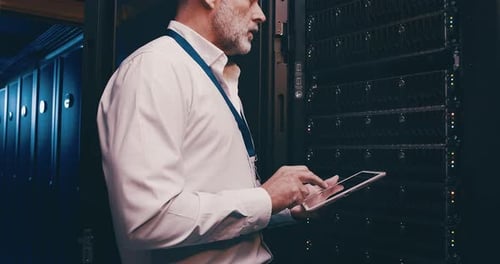 Man in Server Room Using Tablet