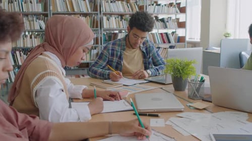 Gruppe verschiedener Schüler mit Migrationshintergrund, die einen Englischtest machen