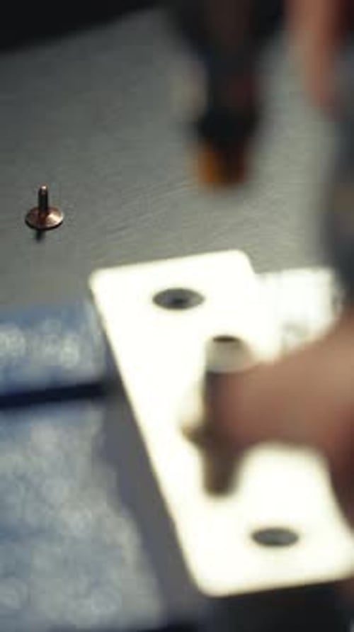 Metal Stud Being Pressed into Denim with Tool