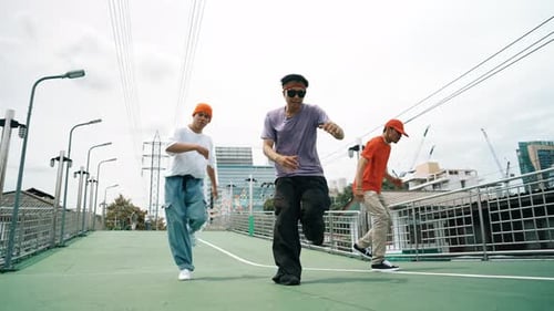 Three Young Men Performing Street Dance on Overpass