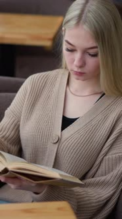 Frau sitzt entspannt und liest ein Buch im gemütlichen Arbeitsraum