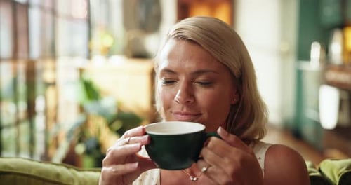 Woman Enjoying Warm Drink on Comfortable Sofa