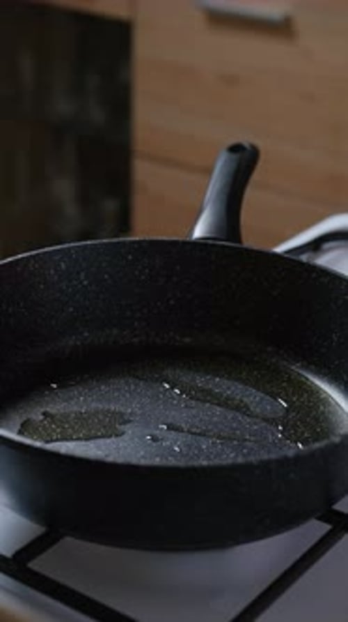 Adding Chopped Onion And Garlic To The Frying Pan