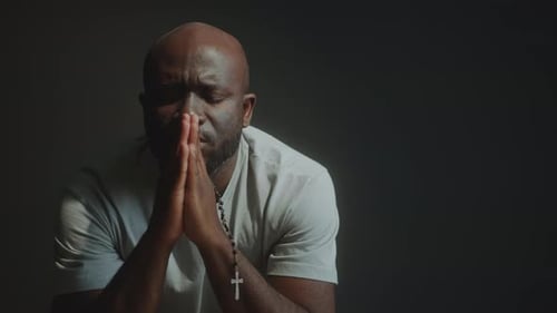 Man Praying with Hands Clasped and Rosary