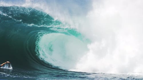 Massive Wave Crashing in Ocean with Distant Surfer