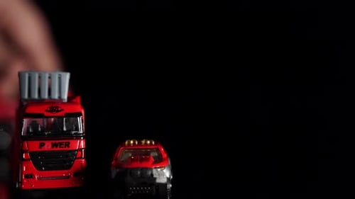 Child's Hand Playing with Toy Cars and Helicopter