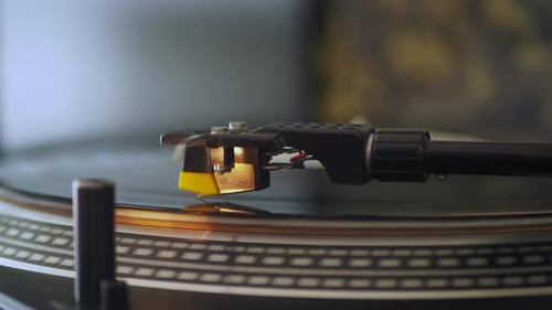 Extreme close up side view of a vinyl record turntable. Included tone arm, cartridge, stylus, needle
