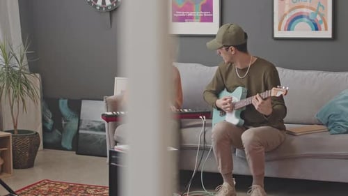 Young Band Playing Guitar and Synthesizer at Home Studio