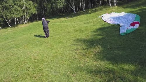 Paraglider untangles cord and getting ready to fly. Extreme sport of paragliding. Preparations for f