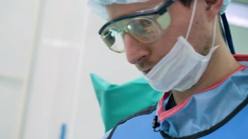 Vista aproximada do rosto de um médico do sexo masculino com um chapéu protetor, óculos e uma máscara médica