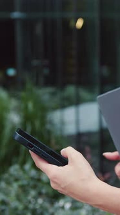 Side View of Close Up Females Hands Using Smartphone and Holding Laptop Fingers Hands Dialing Number