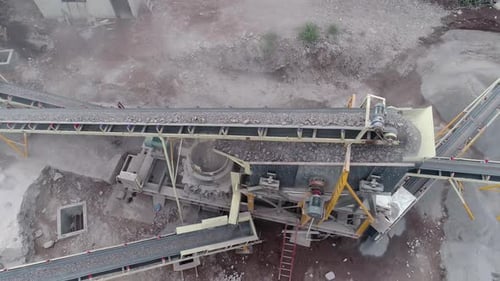 Industriemaschine, die in einem Steinbruch Gestein zu verschiedenen Arten von Kies und Sand zerkleinert - Luftbild