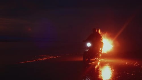 Couple Riding Motorcycle on Beach at Night