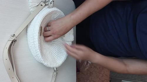 Una mujer muestra un bolso hecho a mano hecho en casa. Vídeo vertical.