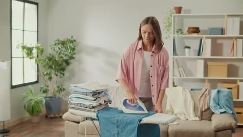 Young Woman Ironing Clothes at Home