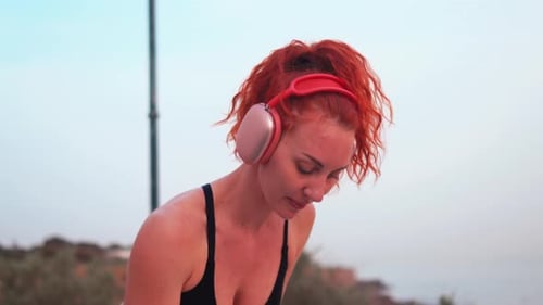 Fit Redhead Woman Working Out with Resistance Band at Outdoor Gym