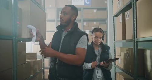 African American Sorting Center Employee Scans Cardboard Boxes Female Manager Checks Inventory on