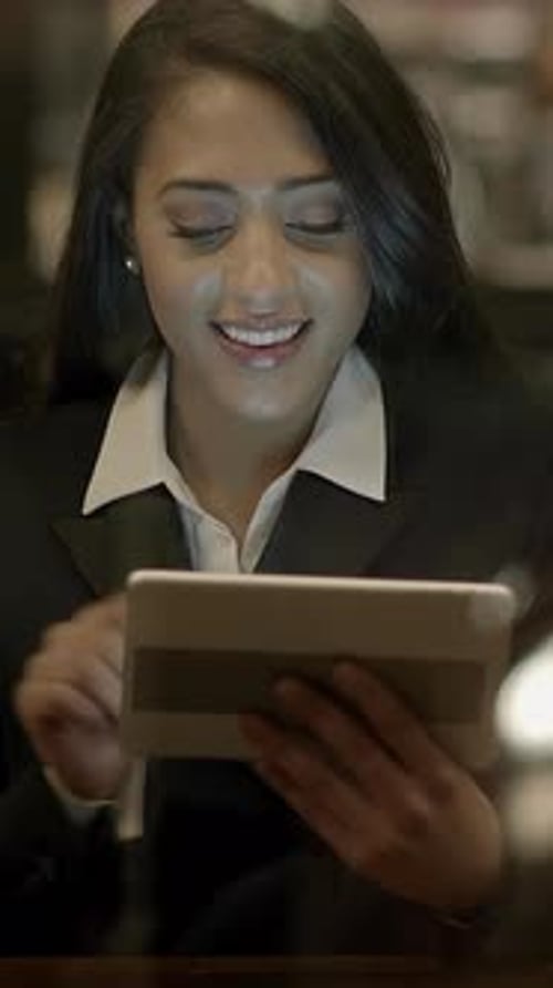 Smiling Woman Uses Tablet in Office Setting