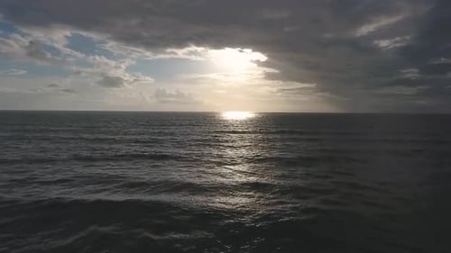 Luftaufnahme des portugiesischen Atlantiks mit Sonnenreflexion im Meer und wunderschöner Wolkenform
