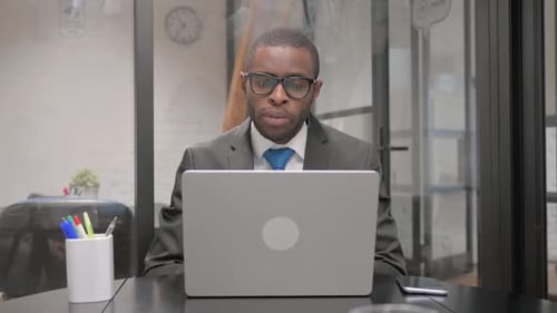 Man Talking at Laptop During Video Conference in Office