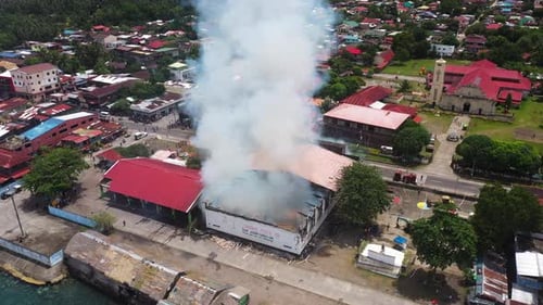 Aerial View Of Gymnasium Building Destructed By Fire With Heavy Smoke Rising In The Philippines. dro