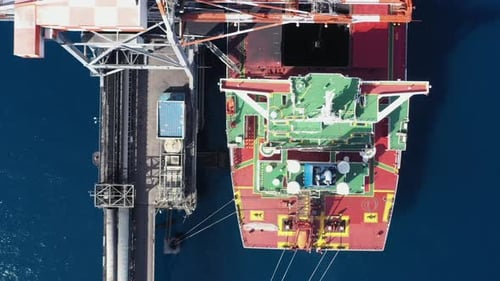 Coal carrier Cargo Ship docked at a commercial pier during unloading operation, Aerial view