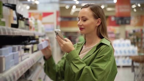 Woman Scanning Product Using Smartphone in Supermarket