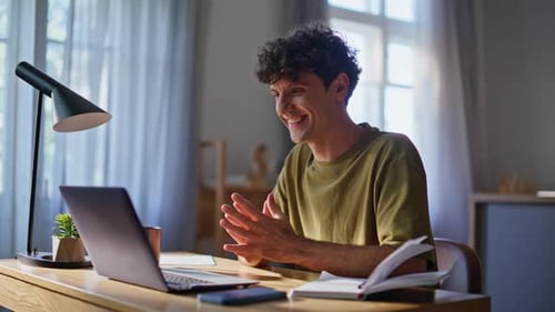 Man Using Laptop for Video Conference at Desk