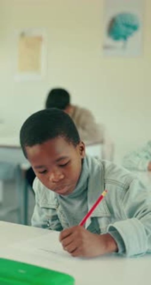 Education, writing and exam with boy in classroom for learning, knowledge and growth
