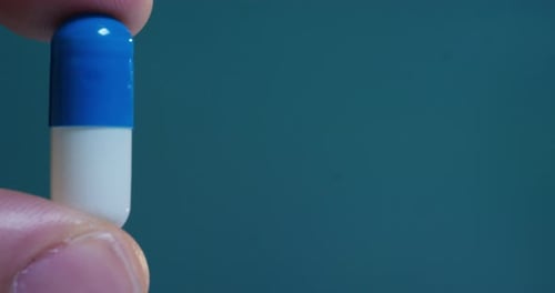 hand of a hospital medical expert shows the pill to be taken to his patient in slow motion