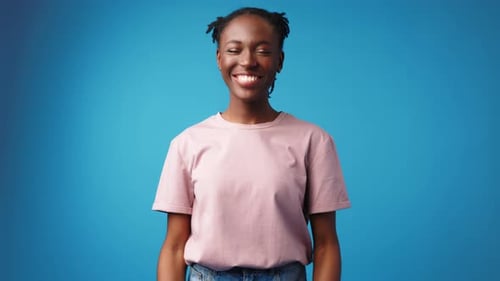 Emotional Ecstatic Young African Woman Celebrates Success on Blue Background in Studio
