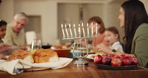 Family Celebrates Hanukkah with Lit Menorah and Challah