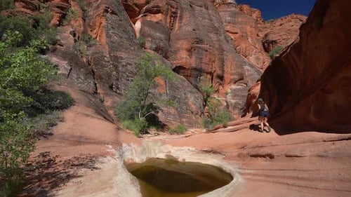 Young Woman Walking in Breathtaking Landscape of Utah Desert, Steep Sandstone Cliffs and Eroded Cany