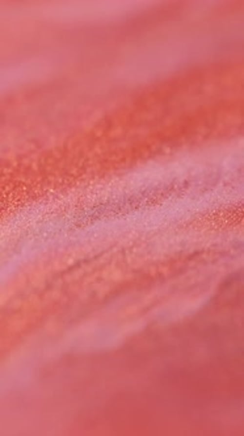 Close up of pink liquid mixing with white