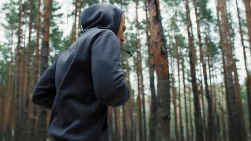 Young Fit Athlete Man Runs in the Forest Morning Outdoor Run in the Nature Healthy Lifestyle