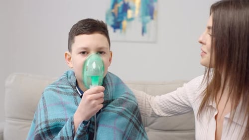 Sick Boy with Nebulizer Being Comforted
