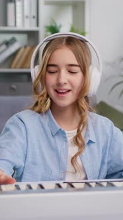 Girl Plays Keyboard Wearing Headphones Indoors