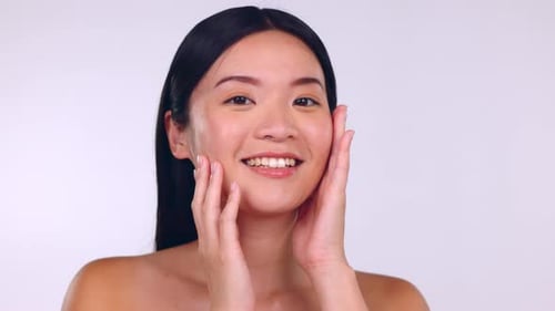 Skincare, facial and Asian woman touch face for wellness, cosmetics and beauty products in studio