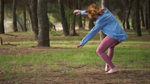 Redhead Young Woman Practicing Contemporary Dance in a Forest