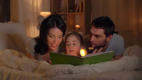Loving parents reading book to their daughter in bed