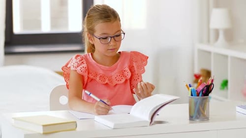 Focused Girl Studying and Writing at Desk Indoors