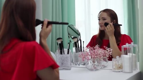 Woman Applies Makeup at Vanity Mirror