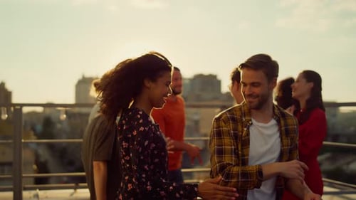 Friends Dancing at Rooftop Party during Golden Hour