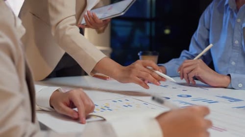 Closeup Asia businesspeople meeting brainstorming some new ideas about project at office night.