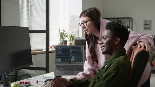 Male Programmer Demonstrating New Vibe Coding Agent to Female Colleague