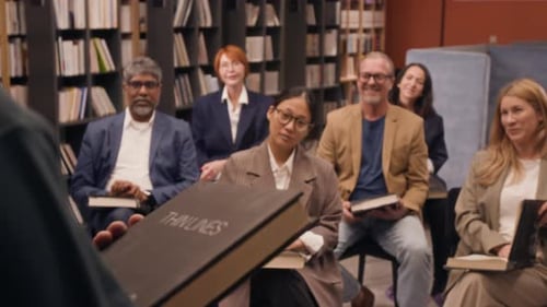 Reading Enthusiasts Having Discussion While Author Presenting Book in Library