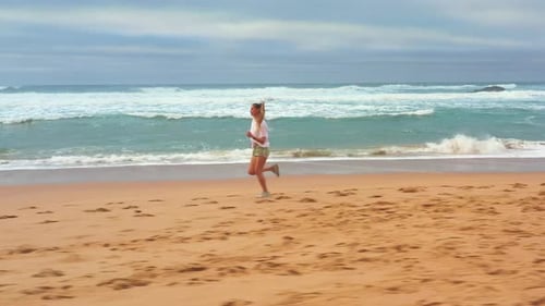 Aerial Drone View Slim Blonde Woman Jogging on Ocean Beach