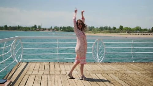 Woman Dancing on a Pier on Sunny Day