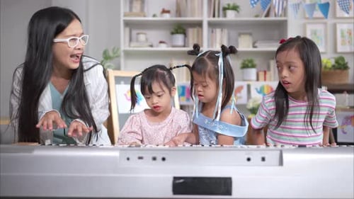 Enthusiastic Teacher Guiding Children in a Piano Lesson
